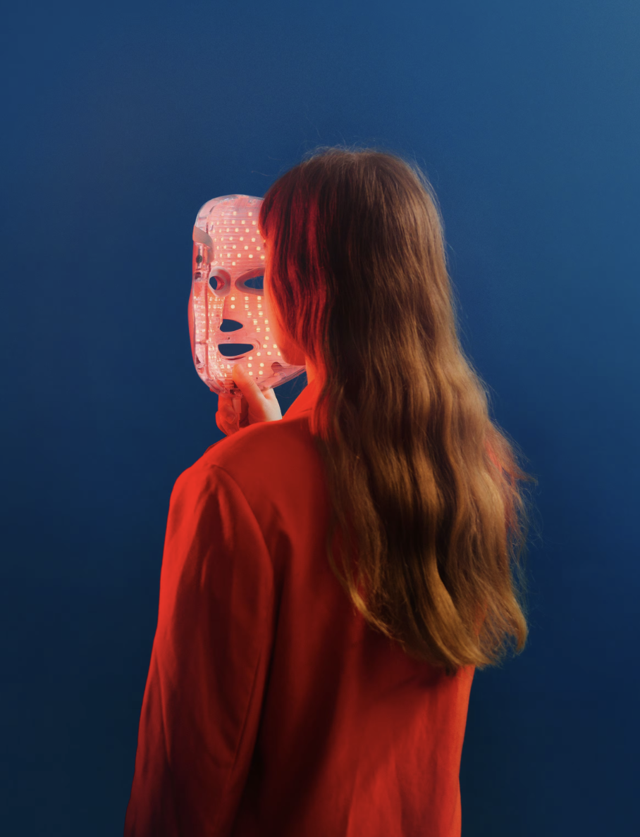 The lit LED mask held up, red diodes glowing